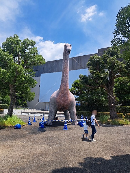 ブラキオサウルスミストバルーンの前を歩く親子