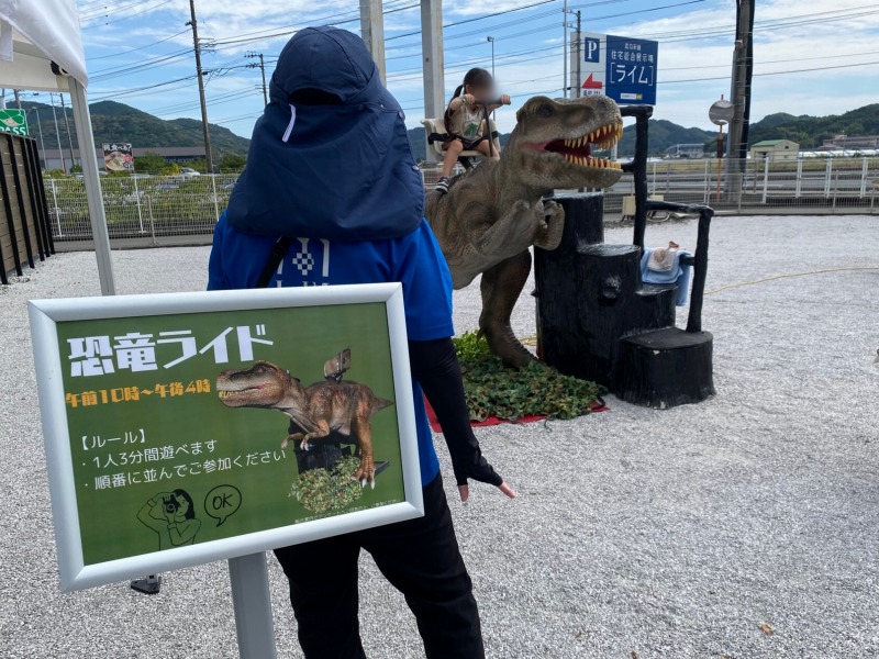 住宅展示場イベントで、恐竜ライドティラノサウルスに乗るお子様